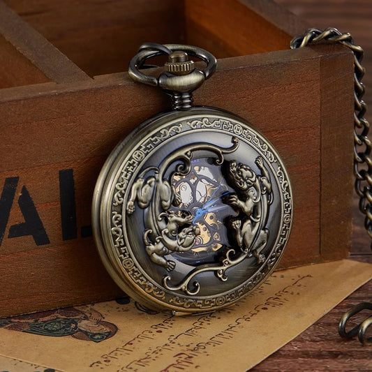 Montre à gousset mécanique chasseur gravée en bronze, capot ajouré à motif animal, posée sur un coffret en bois